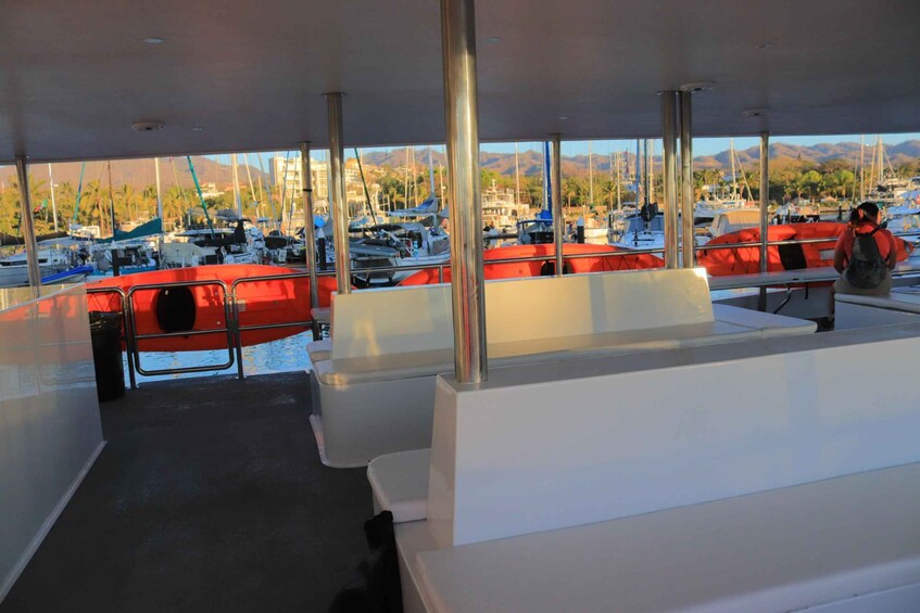 A boat deck with seating and a view of a marina with boats and mountains in the background. 5