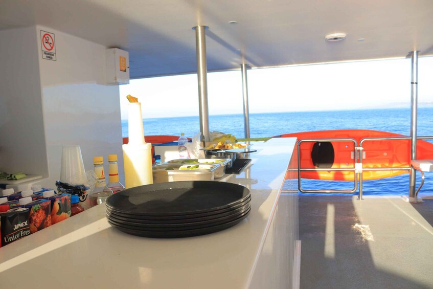 A boat's galley with food items and a stack of plates. 4