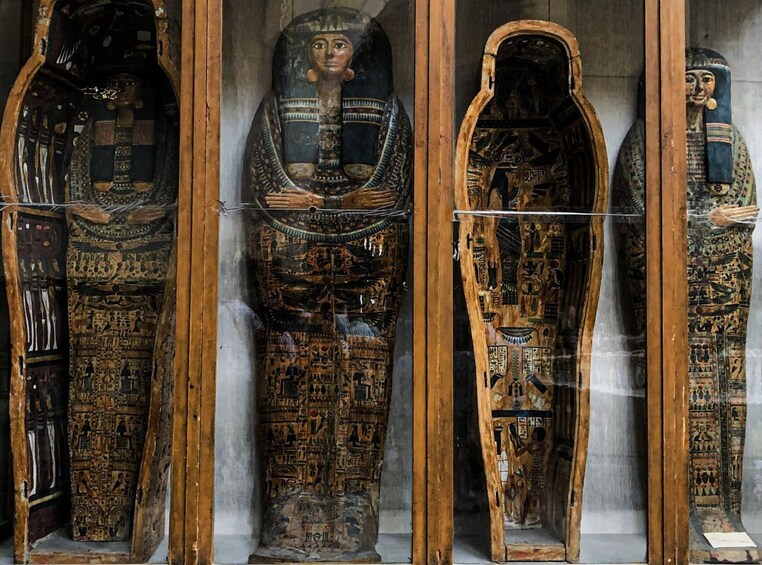 A collection of ancient Egyptian sarcophagi with hieroglyphics and intricate carvings. 3