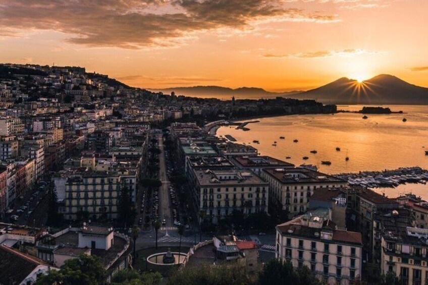 A coastal cityscape at sunset with a mountain in the background. 3