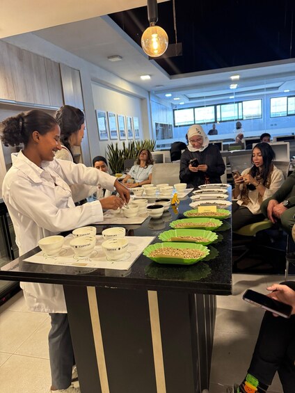 A person preparing coffee cups on a counter in a modern office setting. 5