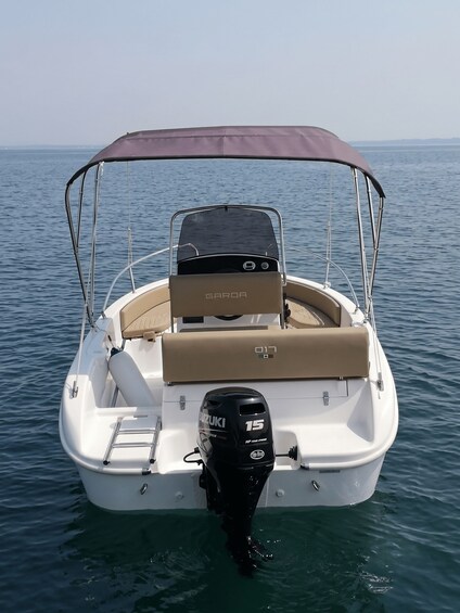 A white motorboat with a canopy, a Suzuki 15 HP outboard motor, and a 'GAROA' brand cooler on the deck. 2