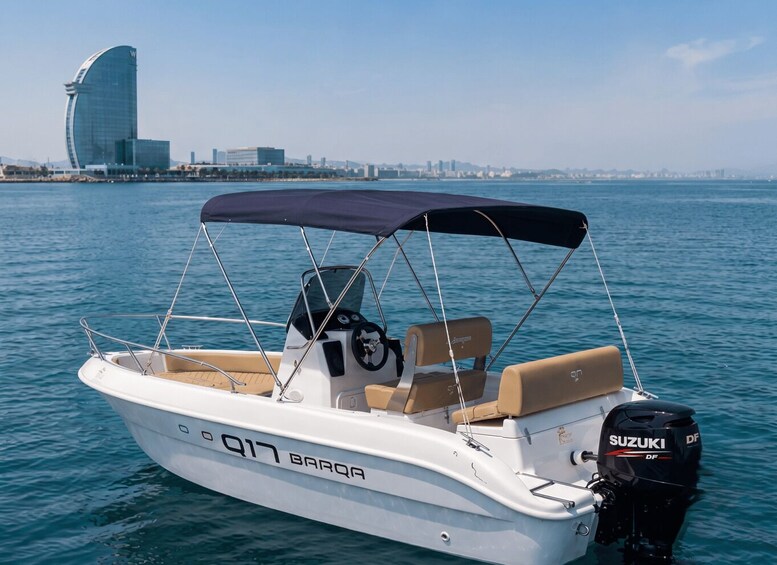 A white motorboat with a Suzuki outboard motor, a canopy, and a city skyline in the background. 1