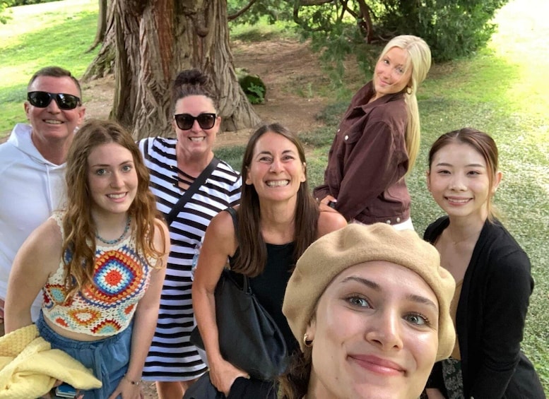 A group of people outdoors near a large tree. 4