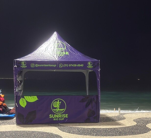 A purple tent with the Sunrise Rio Sup logo and contact information. 2