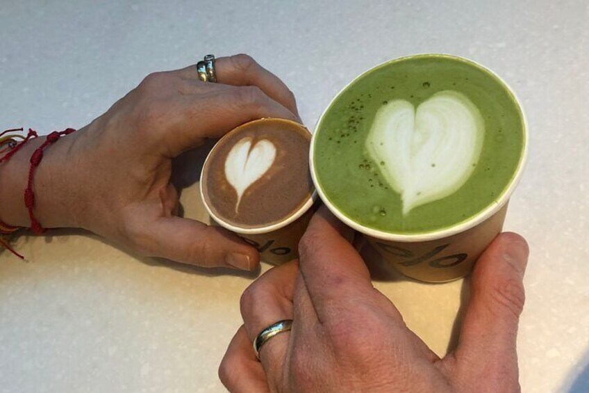 Two hands holding cups of coffee with heart-shaped latte art. 1