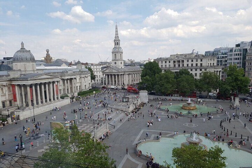 A large public square with historic buildings, a fountain, and a prominent church tower. 3