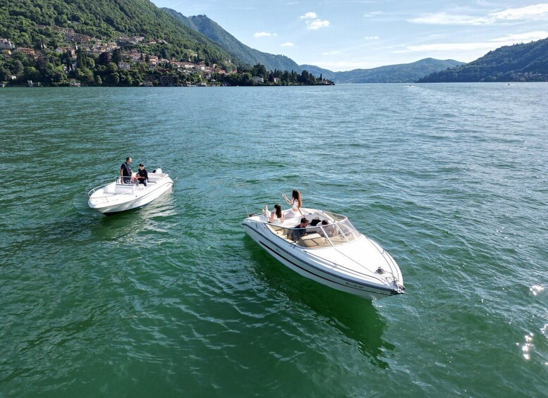 Two speedboats on a calm lake with a mountainous shoreline in the background. 2