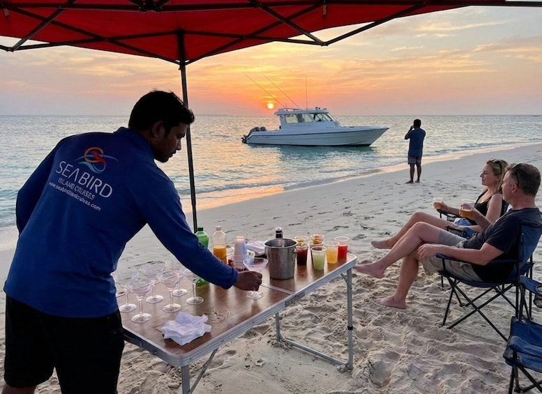 A beach scene with a sunset, a boat, and people relaxing under a canopy. 5