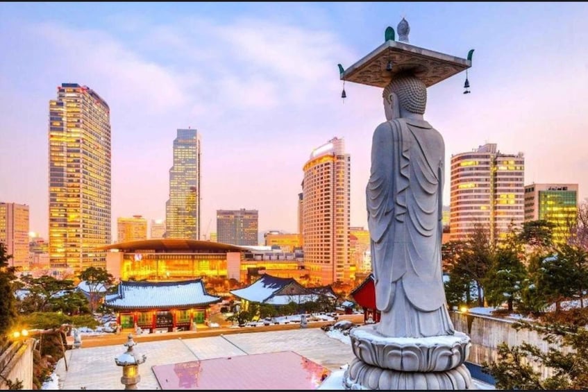 A statue of a seated figure with a bowl on its head, a traditional building with a curved roof, and modern high-rise buildings in the background. 3