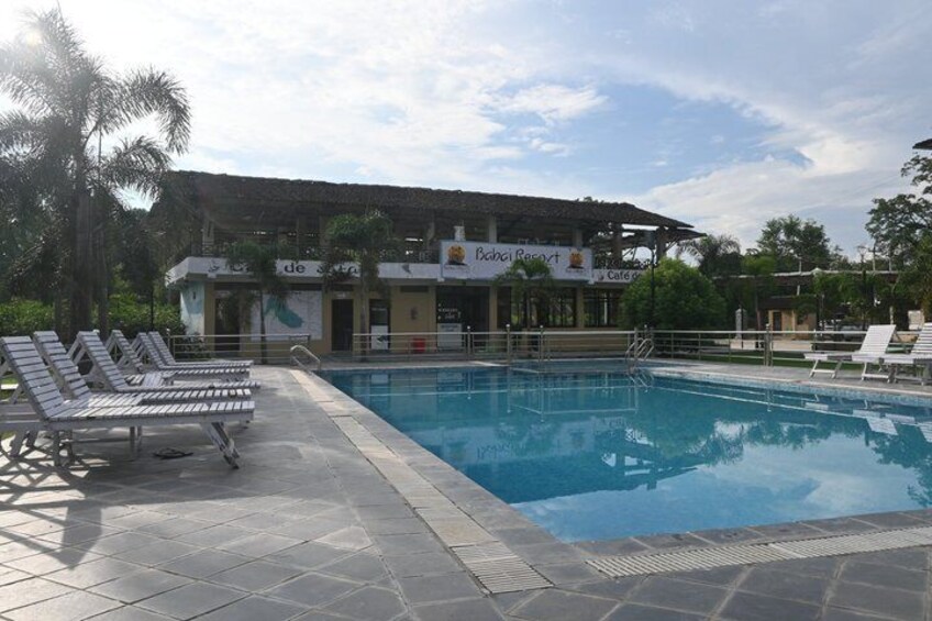 A swimming pool with lounge chairs, a building labeled 'Bacardi Resort,' and palm trees. 3