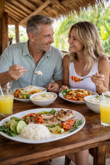 Two people dining at an outdoor table with various dishes and drinks. 1