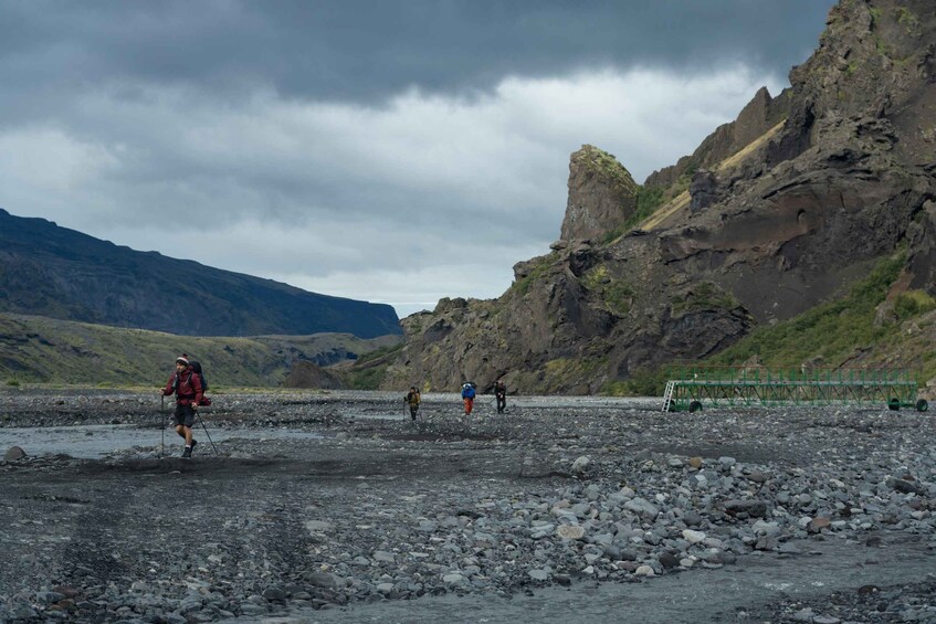 A group of hikers on a rocky terrain with a mountain in the background. 1