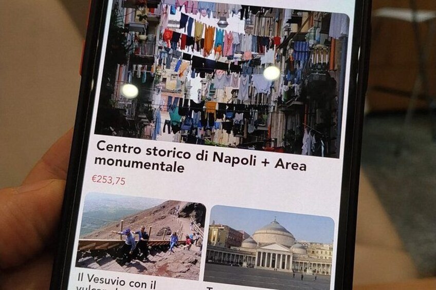 A smartphone displaying a travel guide for the historic center of Naples and the monumental area, with a price of €253.75. 2