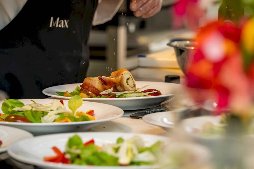A chef in a black apron preparing food in a kitchen. 4
