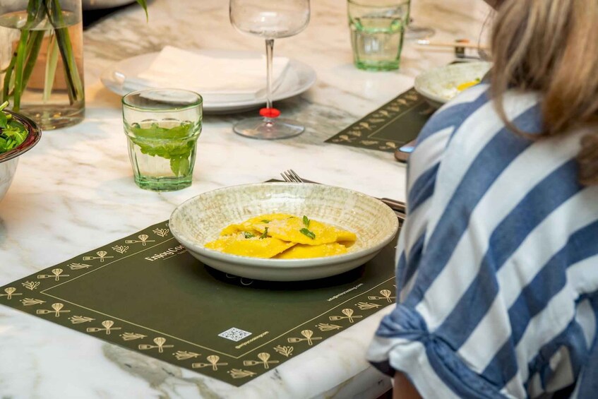 A dining table with a plate of food, a glass of water, and a wine glass. 3
