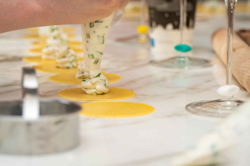 A person piping cream onto a dessert base. 5