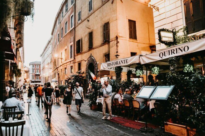 A bustling street with outdoor seating at a restaurant named 'Quirino.' 2