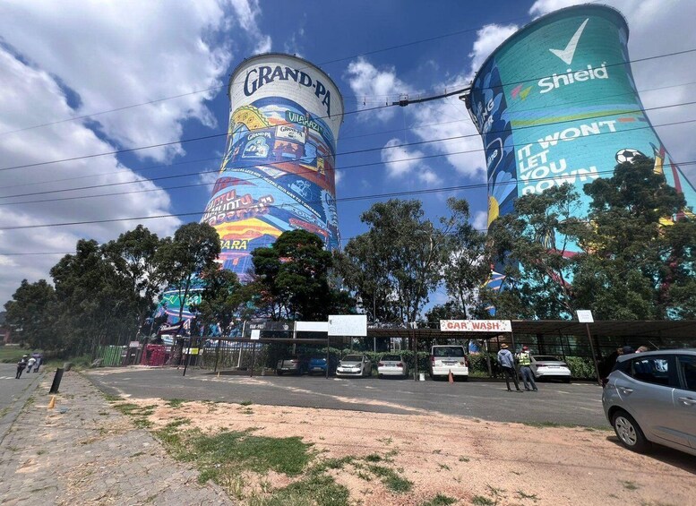 A mural on a cylindrical water tower with the text 'Grand-Pa' and 'Shield' visible. 1