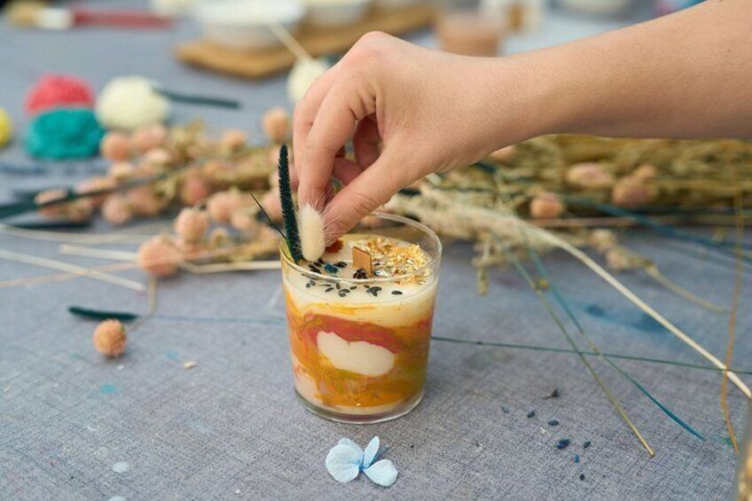 A hand stirring a layered drink in a glass with a straw. 3