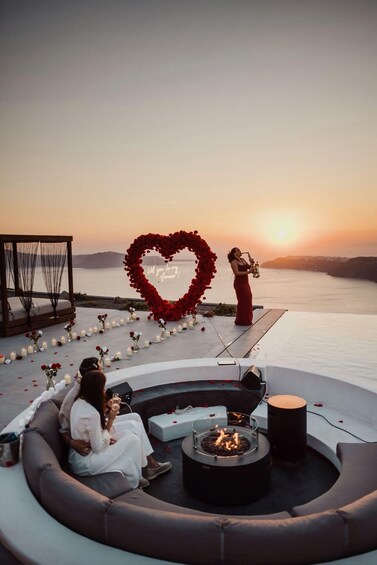 A sunset wedding ceremony with a heart-shaped arch and a couple seated on a sofa. 2