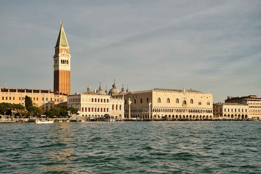 A historic waterfront with a prominent bell tower and a large building with a dome. 1