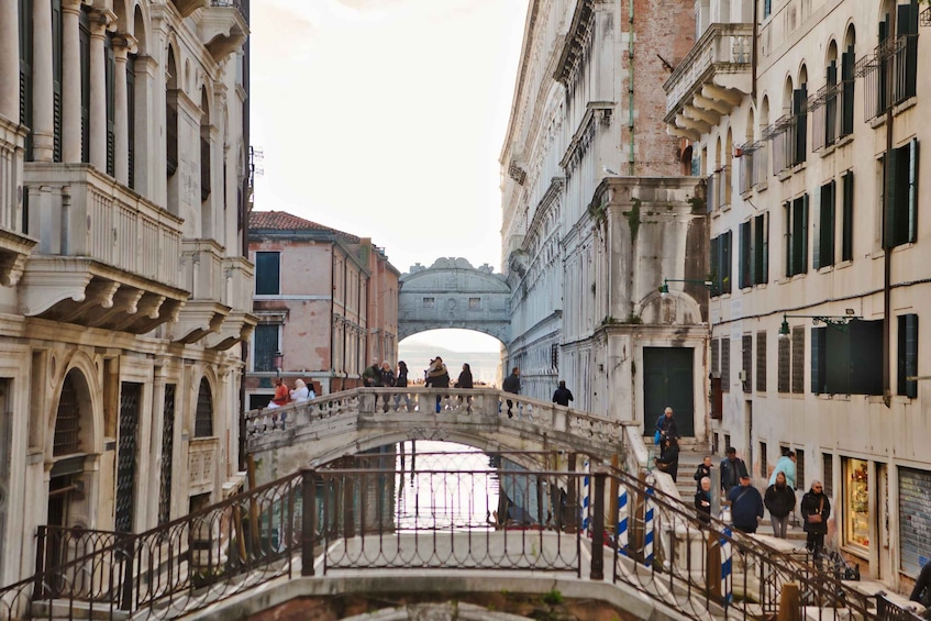 A historic bridge in Venice with people walking across it. 4