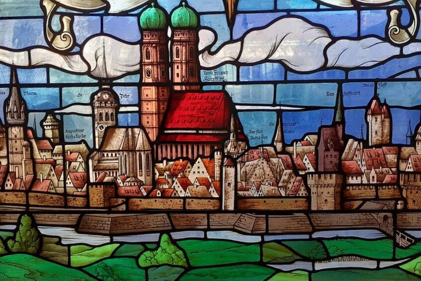A stained glass window depicting a town with a prominent church, towers, and a river. 1
