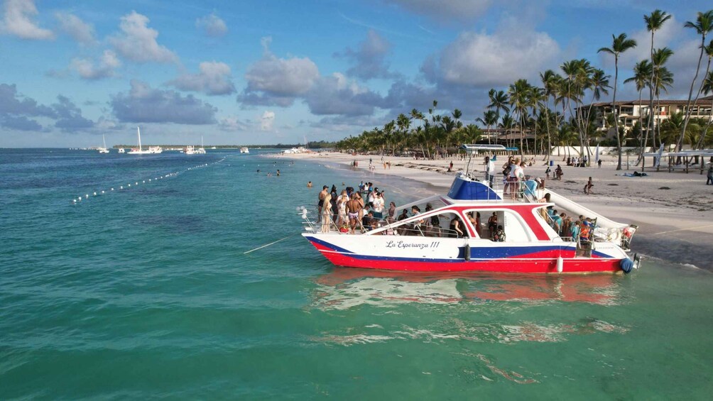 A boat named 'La Esperanza 111' on calm turquoise waters near a beach with palm trees and a clear sky. 1
