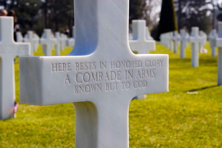 A white cross with an inscription in a cemetery. 3