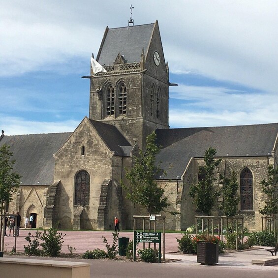 A historic church with a clock tower, a public toilet sign, and a visitor information sign. 2