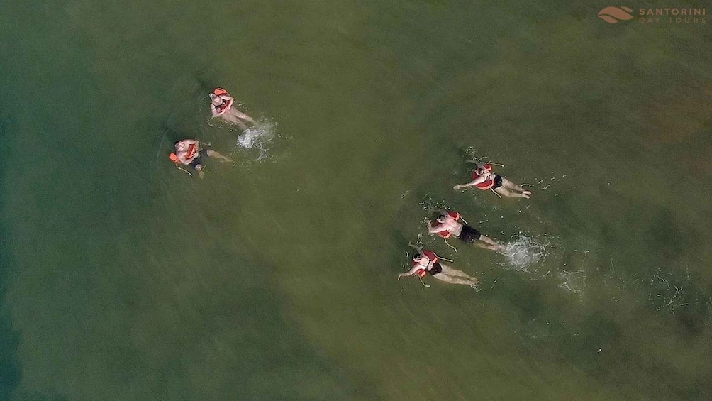 An aerial view of a group of people swimming in a body of water. 3