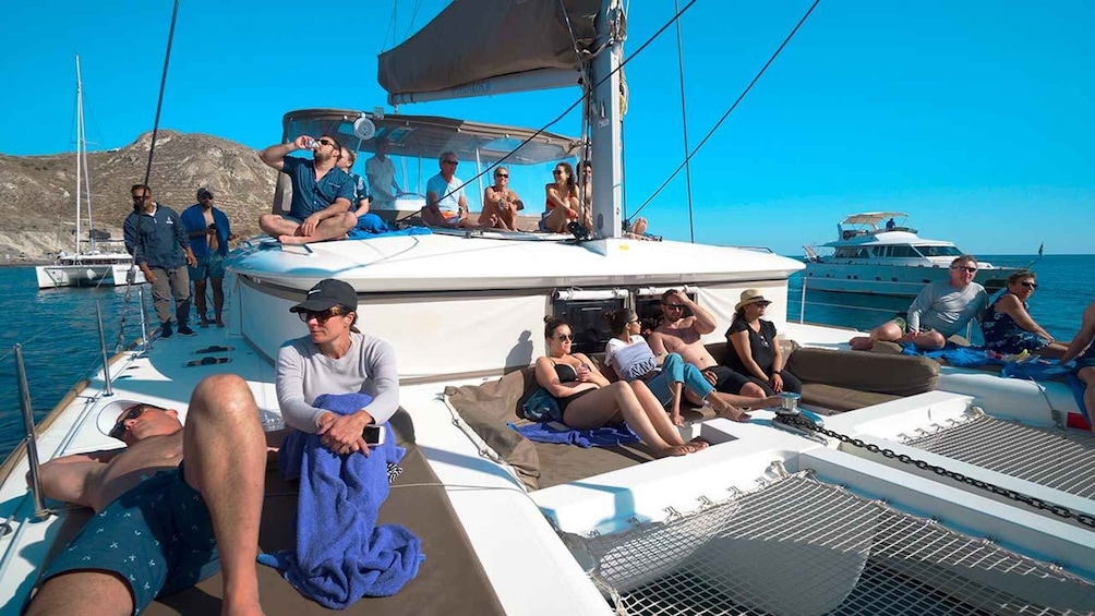 People relaxing on a sailboat with a clear blue sky and calm sea in the background. 4