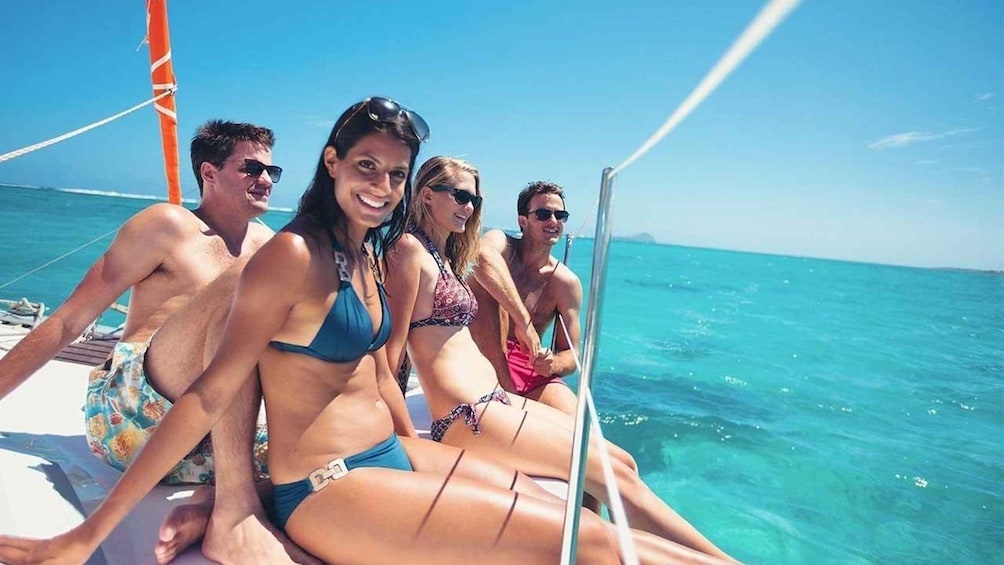 A group of people on a boat with a clear blue sea and sky in the background. 1