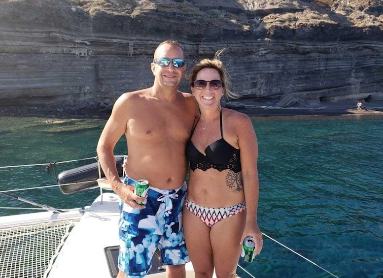 Two people on a boat with a rocky cliff in the background. 5