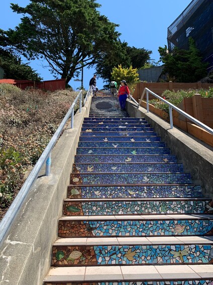 A staircase with mosaic tiles and metal railings. 5