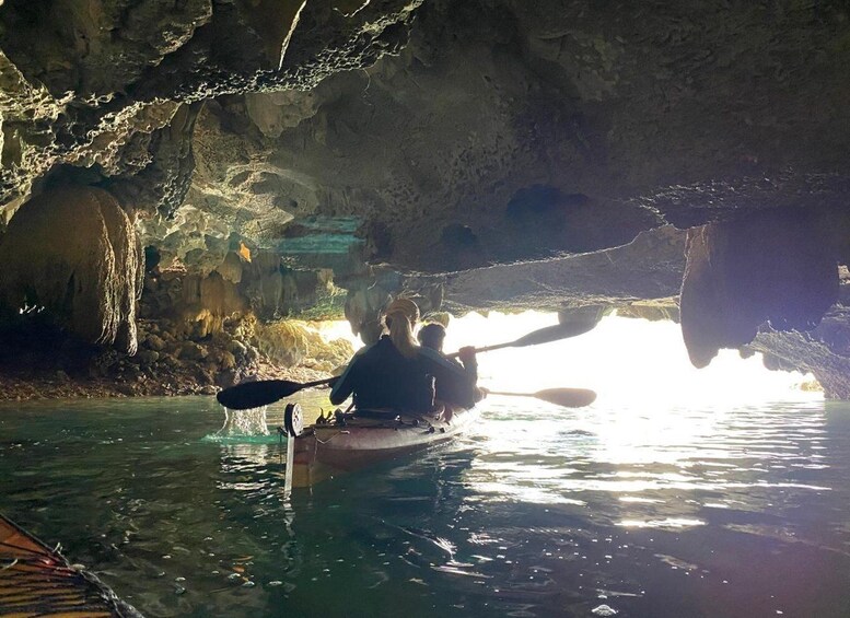 A person kayaking in a cave with stalactites. 2