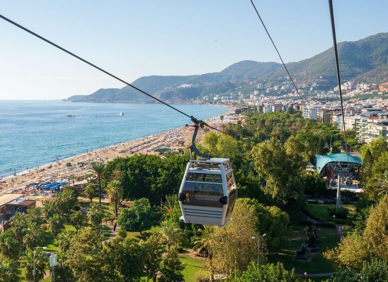 A cable car over a coastal city with a beach and urban buildings. 4