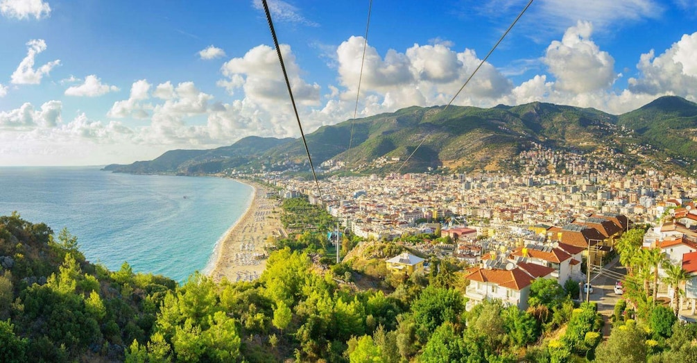 A coastal city with a beach, mountains, and a cable car line. 3