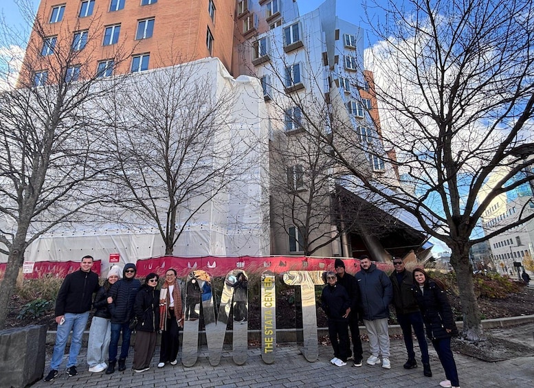 A group of people standing in front of a large, reflective sculpture with the text 'THE SITA CENTER' on it. 4