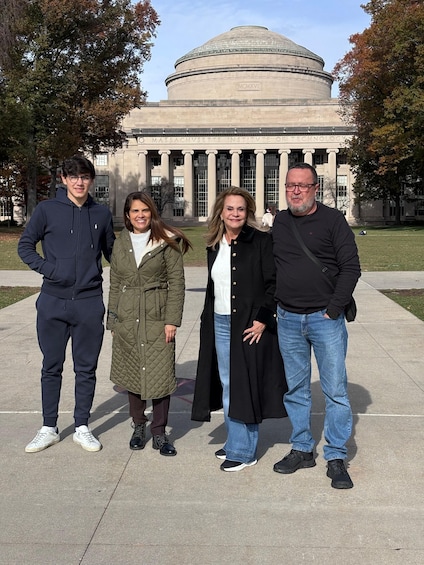 A group of people standing in front of a large building with columns and a dome, surrounded by trees. 3