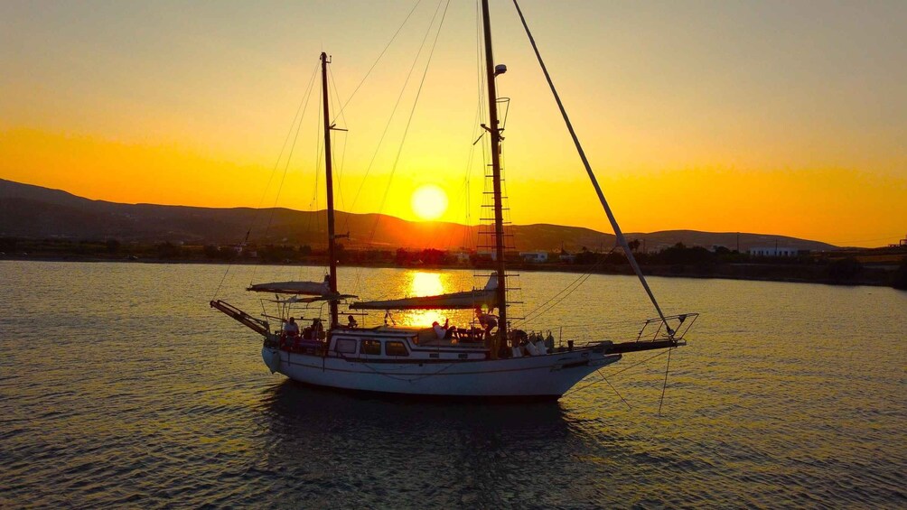 A sailboat on calm waters during sunset with the sun low on the horizon. 3