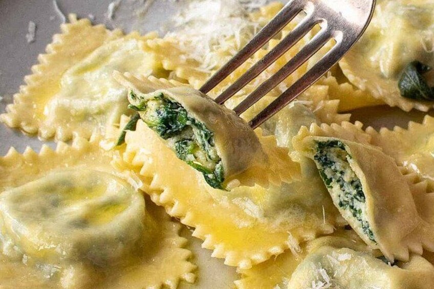 Ravioli with a fork, some sauce, and a fork in the background. 2