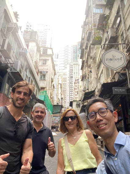 A group of people standing on a city street with tall buildings and a coffee shop sign. 2