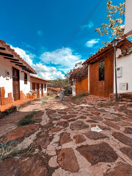 A cobblestone street lined with traditional white and brown buildings, under a clear blue sky. 3