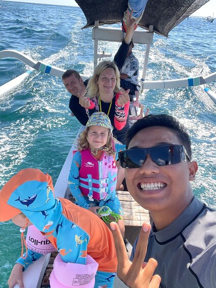 A group of people on a boat with a wake behind them. 4