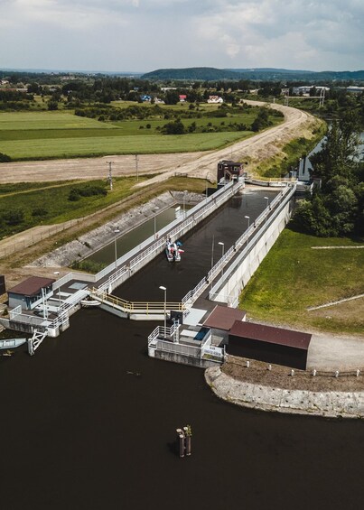 A lock system with boats, a lock house, and surrounding greenery. 3