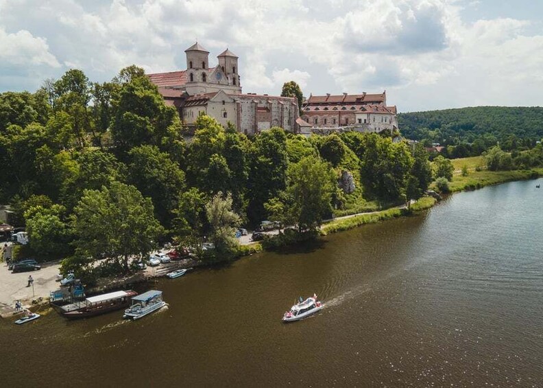 A historic castle by a river with boats docked nearby. 1