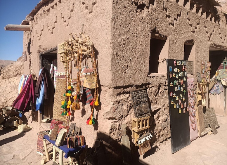 A traditional mud-brick building with hanging textiles and wooden carvings. 2