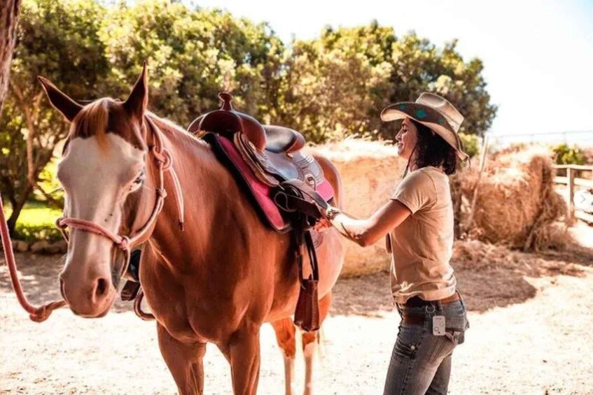 A person leading a horse with a saddle. 3